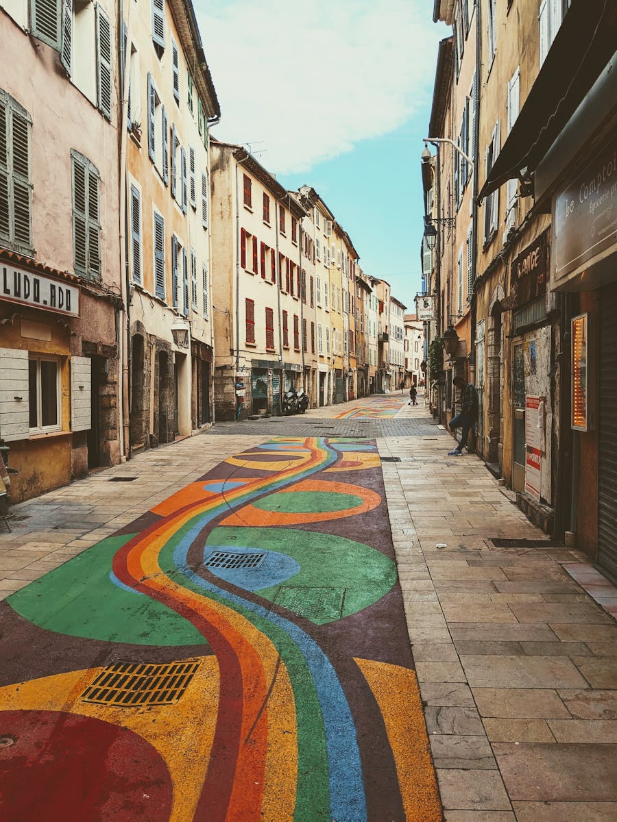Vibrant street art decorates a quiet alley in the historic town of Draguignan, France.