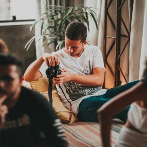 Photo by Matheus Bertelli Young photographers work together in a creative, indoor studio workshop setting.